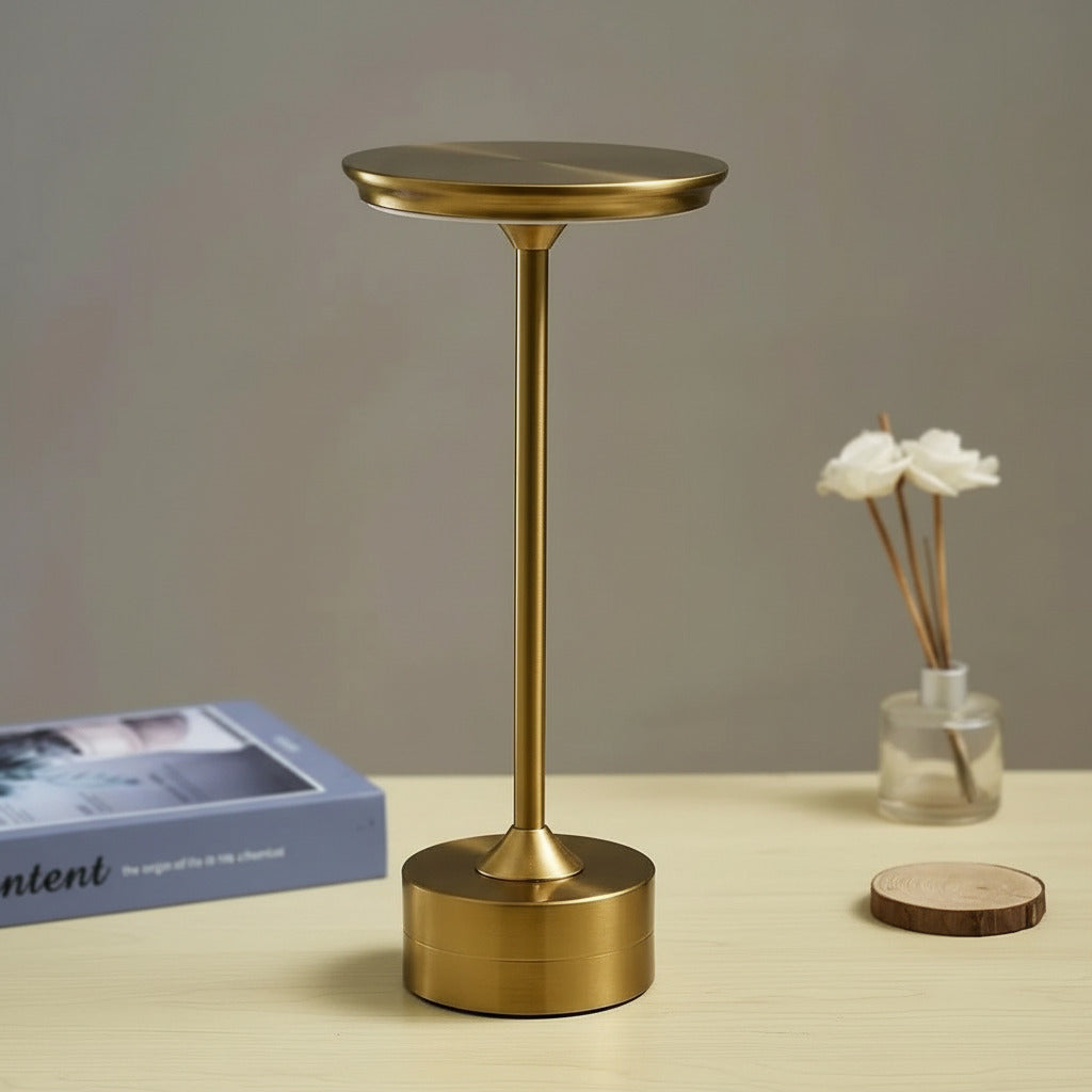 Luminária LED dourada sobre mesa de madeira na mesa de estudos