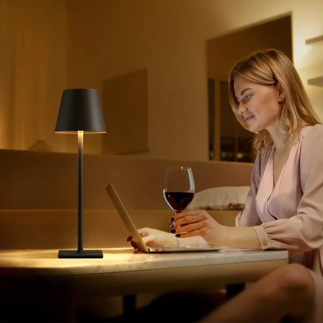 Luminária de mesa preta LED moderna em ambiente noturno, iluminando mesa com design elegante para sala, quarto ou restaurante.
